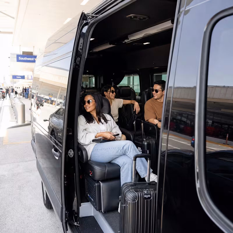 Passengers loading luggage while boarding an Fresno group shuttle