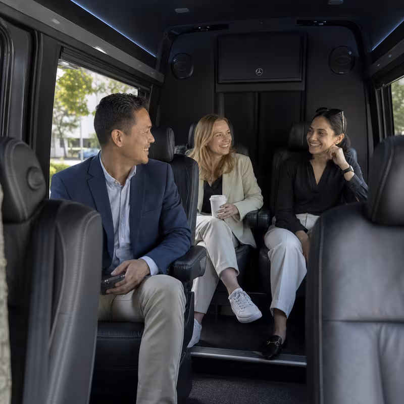 Group boarding a white charter bus for Corporate Transportation transportation in Fresno