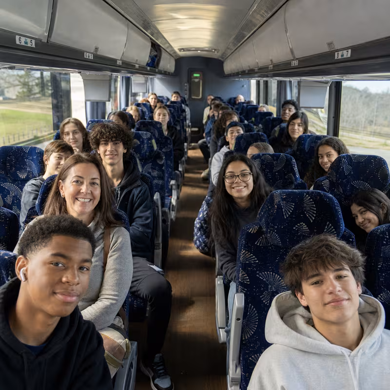 Group boarding a white charter bus for School Transportation transportation in Fresno