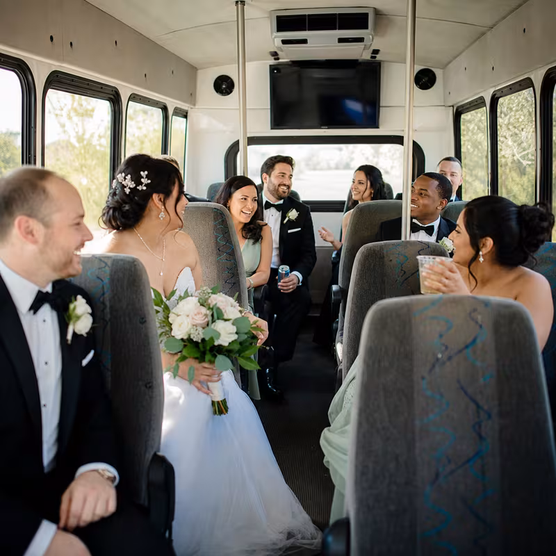 Group boarding a white charter bus for Wedding Transportation transportation in Fresno