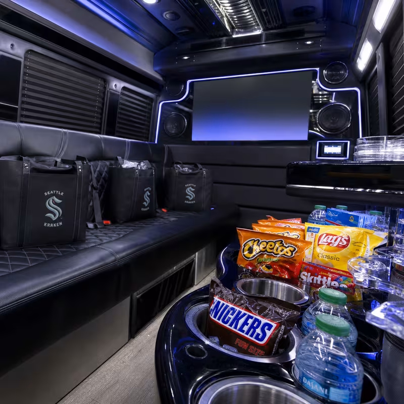 Party bus interior with wraparound leather seating and LED lighting in Fresno